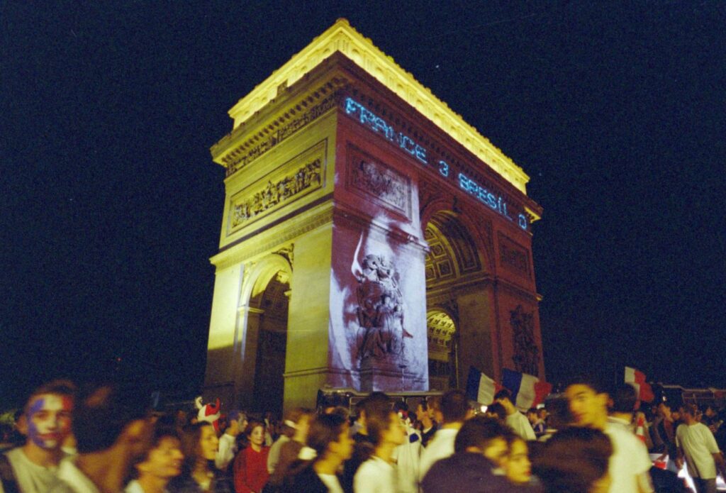 L’historienne Naïma Yahi propose de patrimonialiser les deux buts de Zinédine Zidane en finale de Coupe du monde 1998 (visage de Zidane projeté sur l’Arc de Triomphe, 12/07/1998 ©AFP).